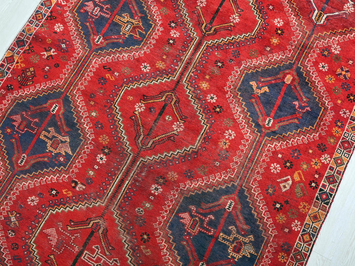 a red rug with a blue and red design on it