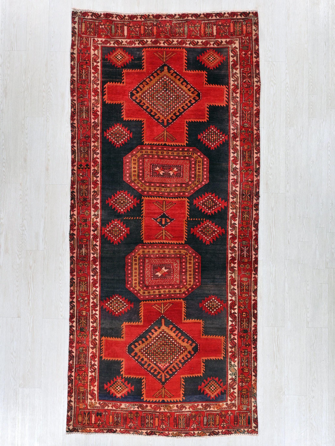 a red and black rug hanging on a wall