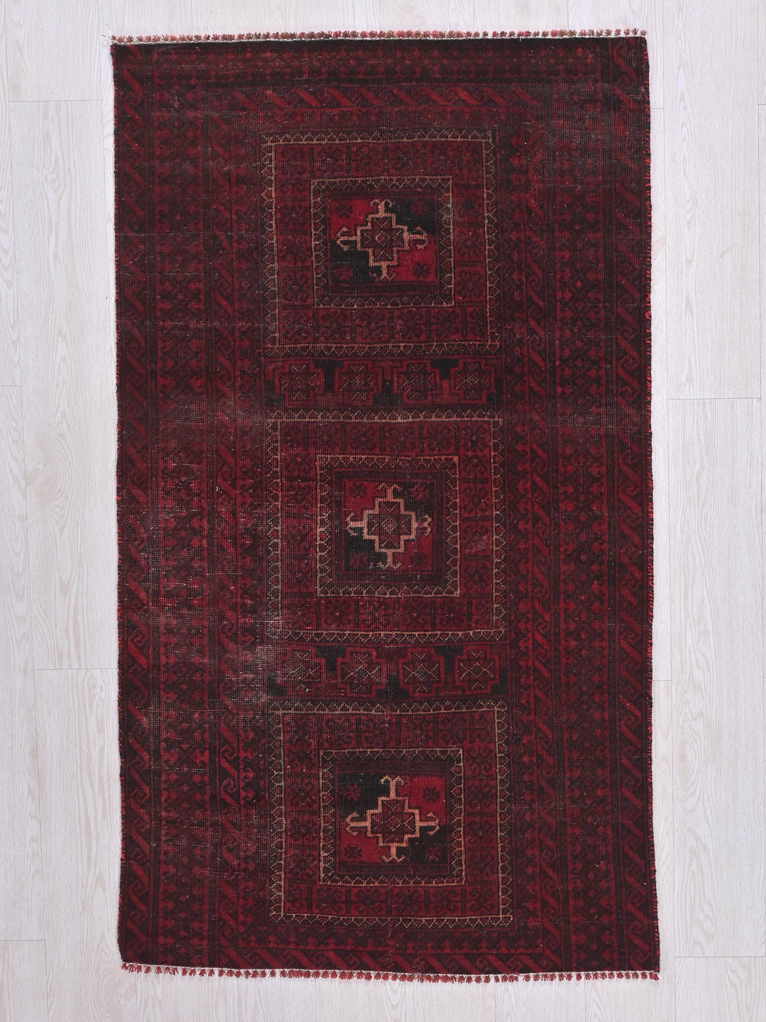 a red rug on a white wooden floor