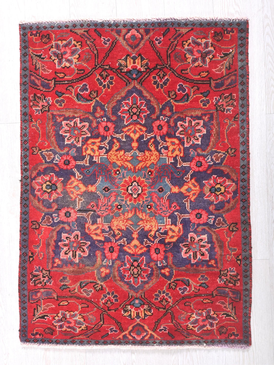 a red rug with a blue and red design on it