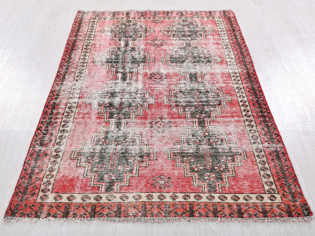 a red and black rug on a white floor