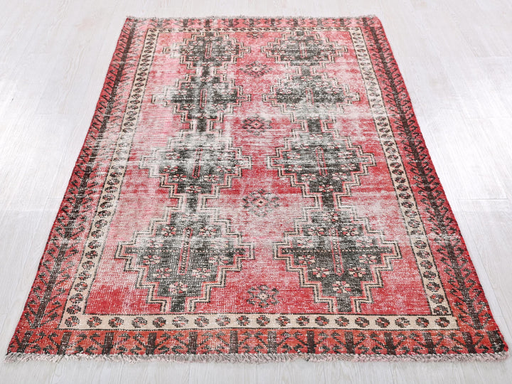 a red and black rug on a white floor