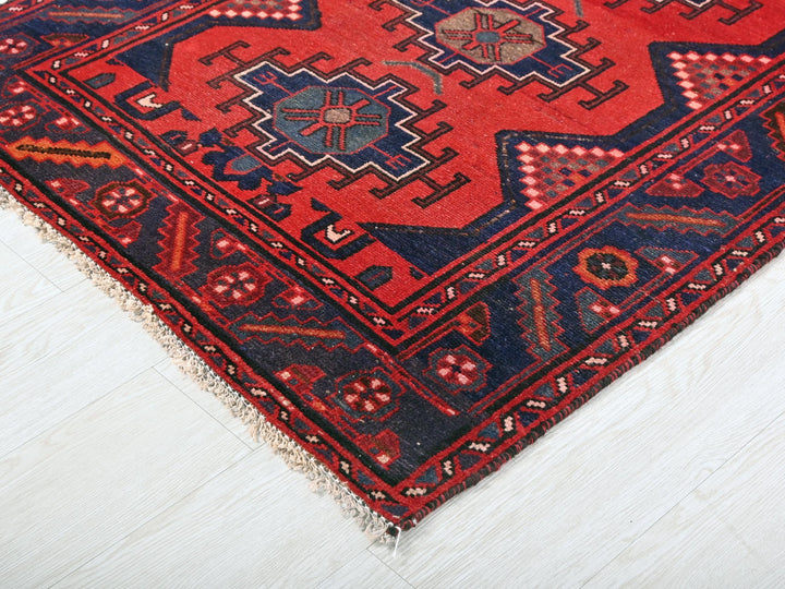 a red and blue rug on a white floor