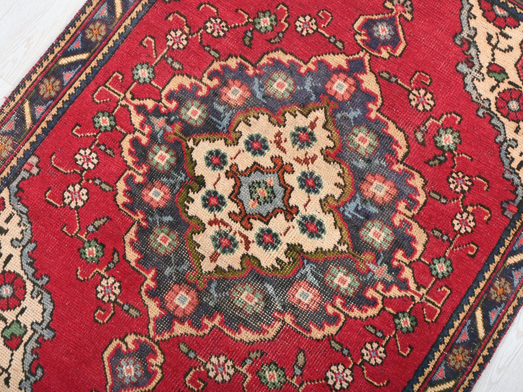 a close up of a red rug on a wooden floor