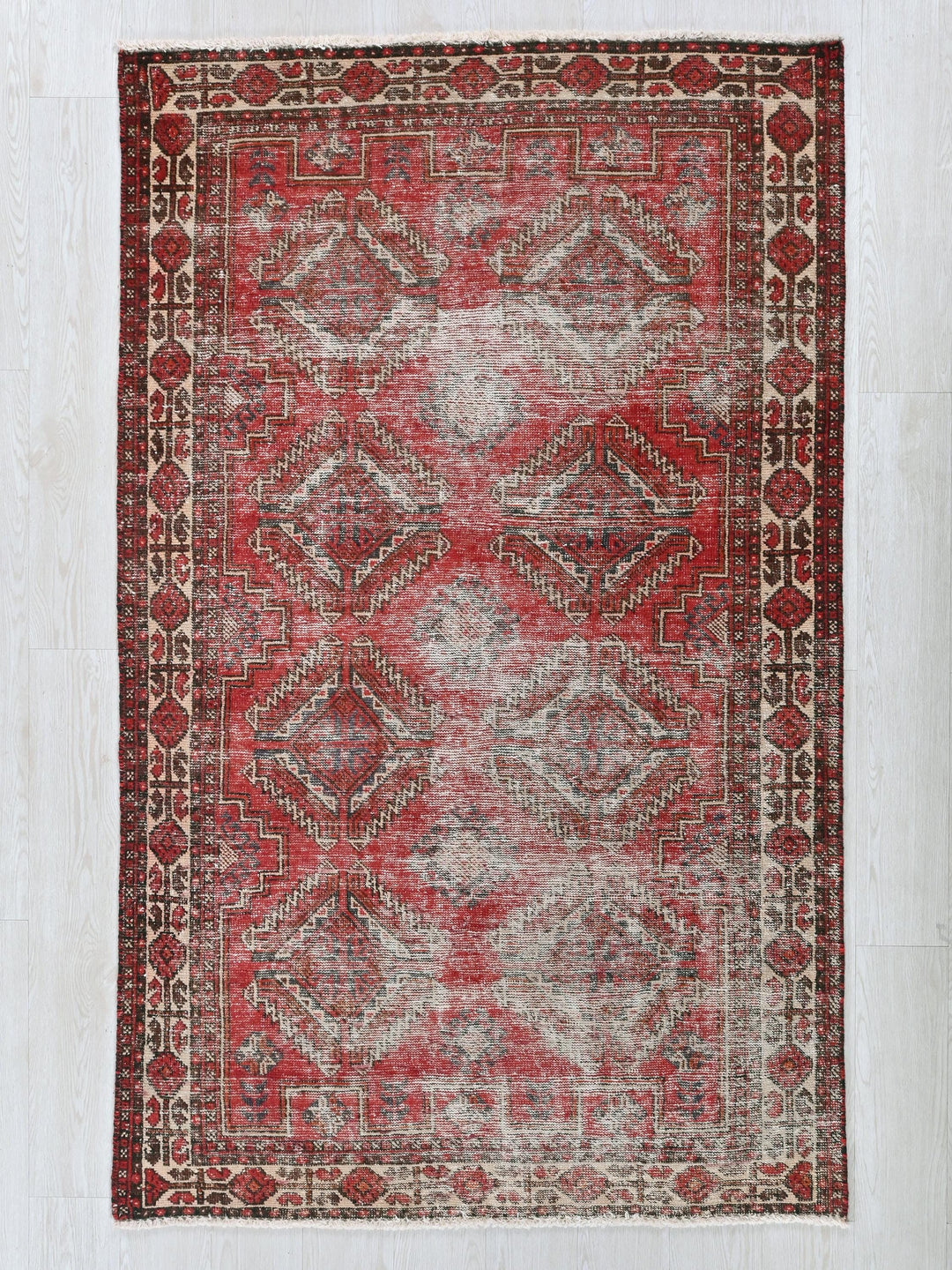 a red rug with a pattern on the middle of it