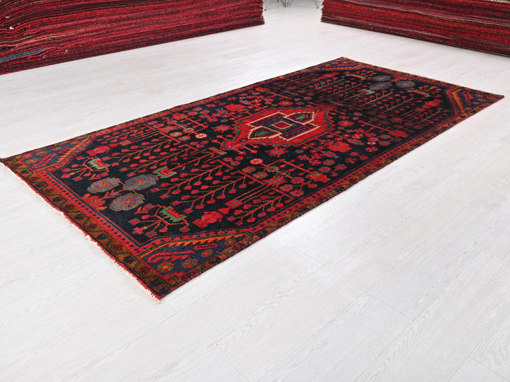 a red and black rug on a white floor