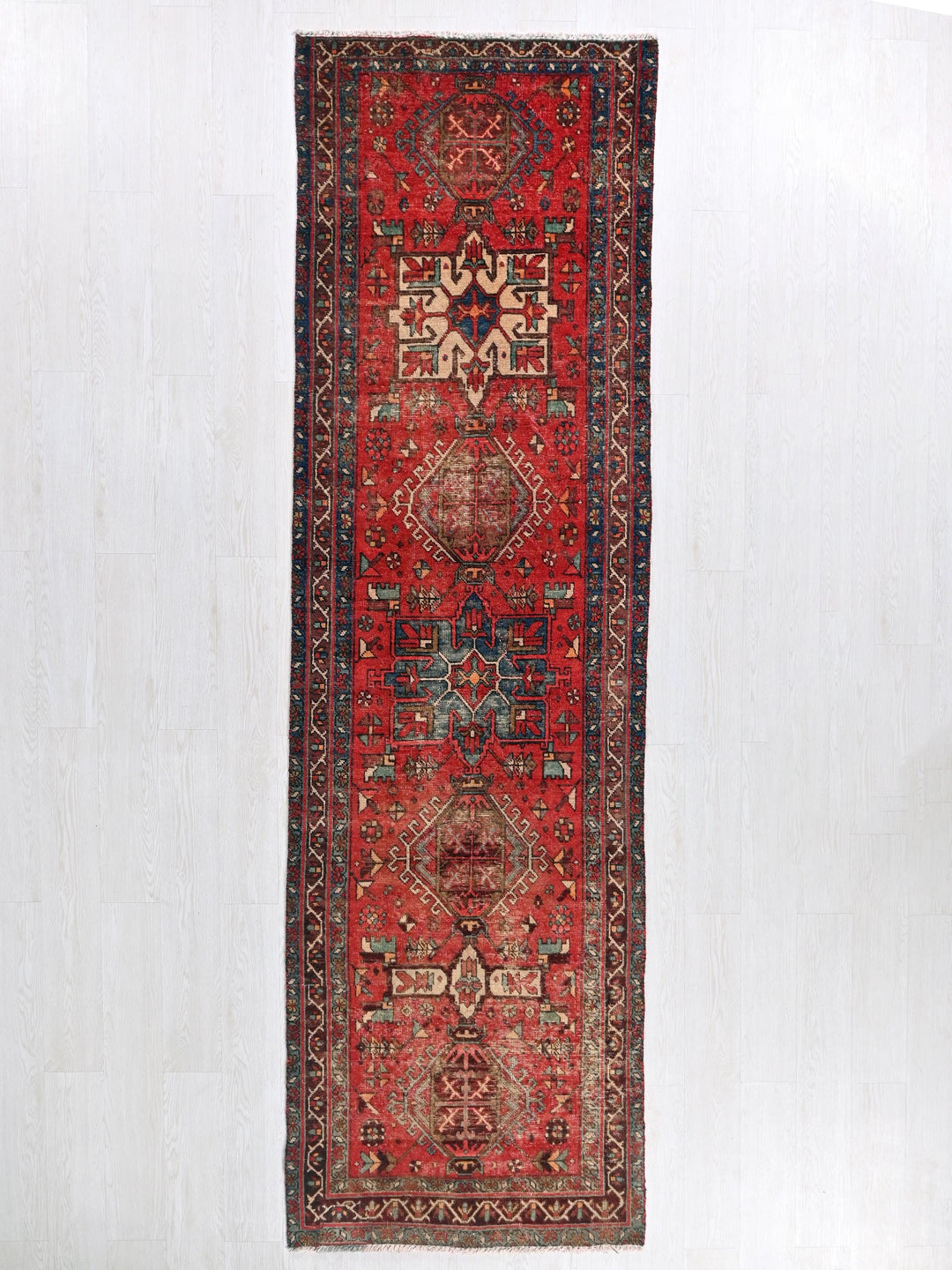 a red rug hanging up against a white wall