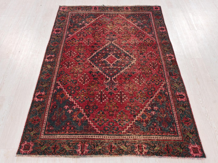 a red and black rug on a white floor