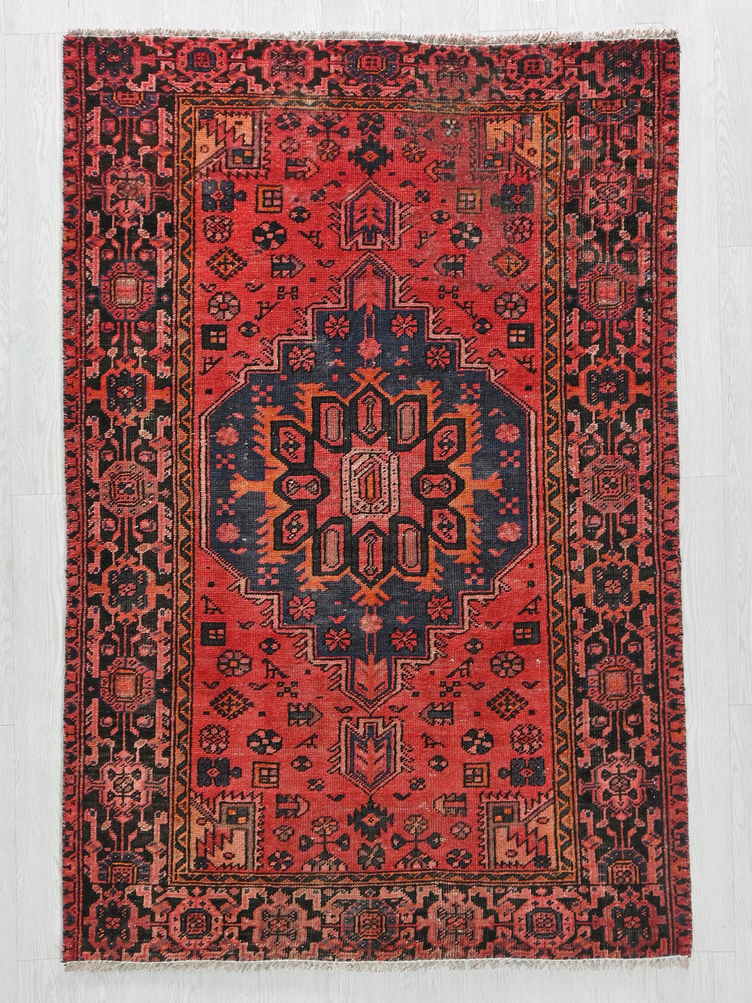 a red rug with a blue and yellow design