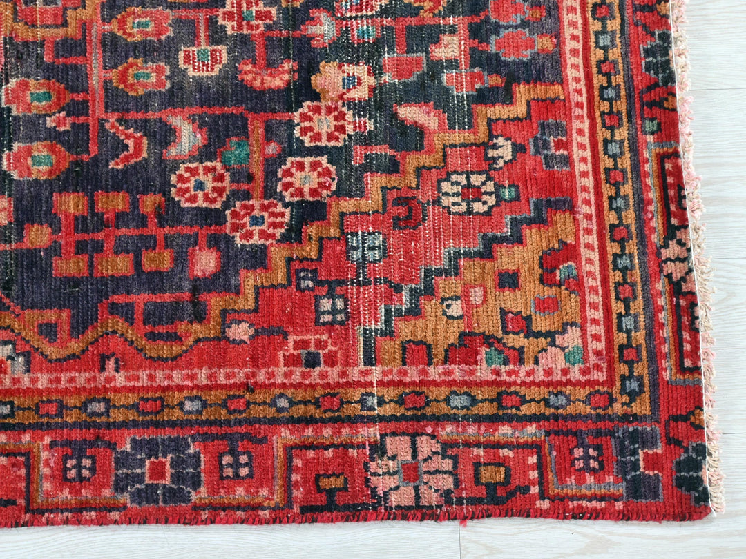 a red, blue, and yellow oriental rug on a white surface