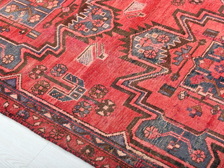 a red rug with a blue and pink design on it