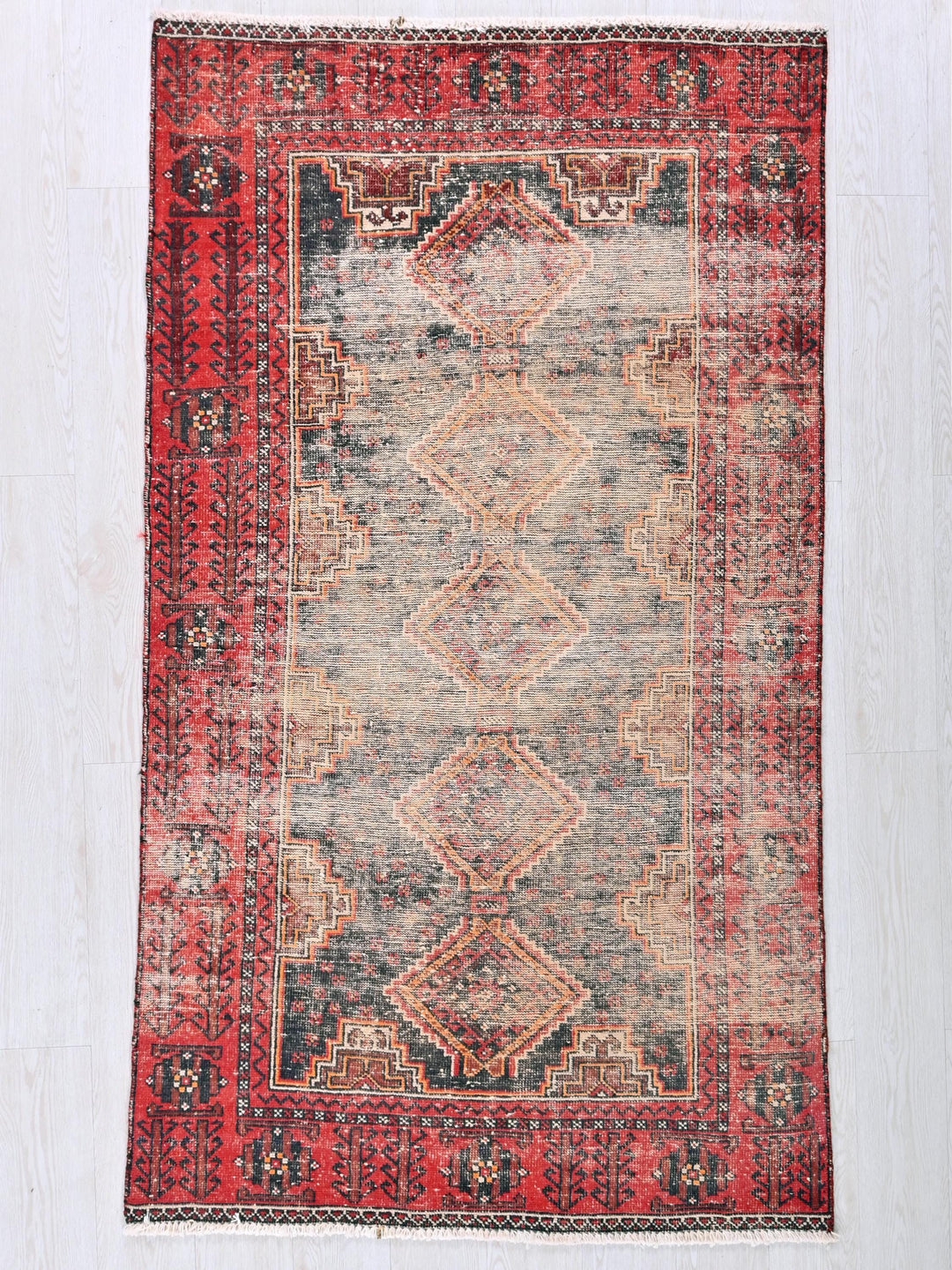 a red and blue rug on a white floor