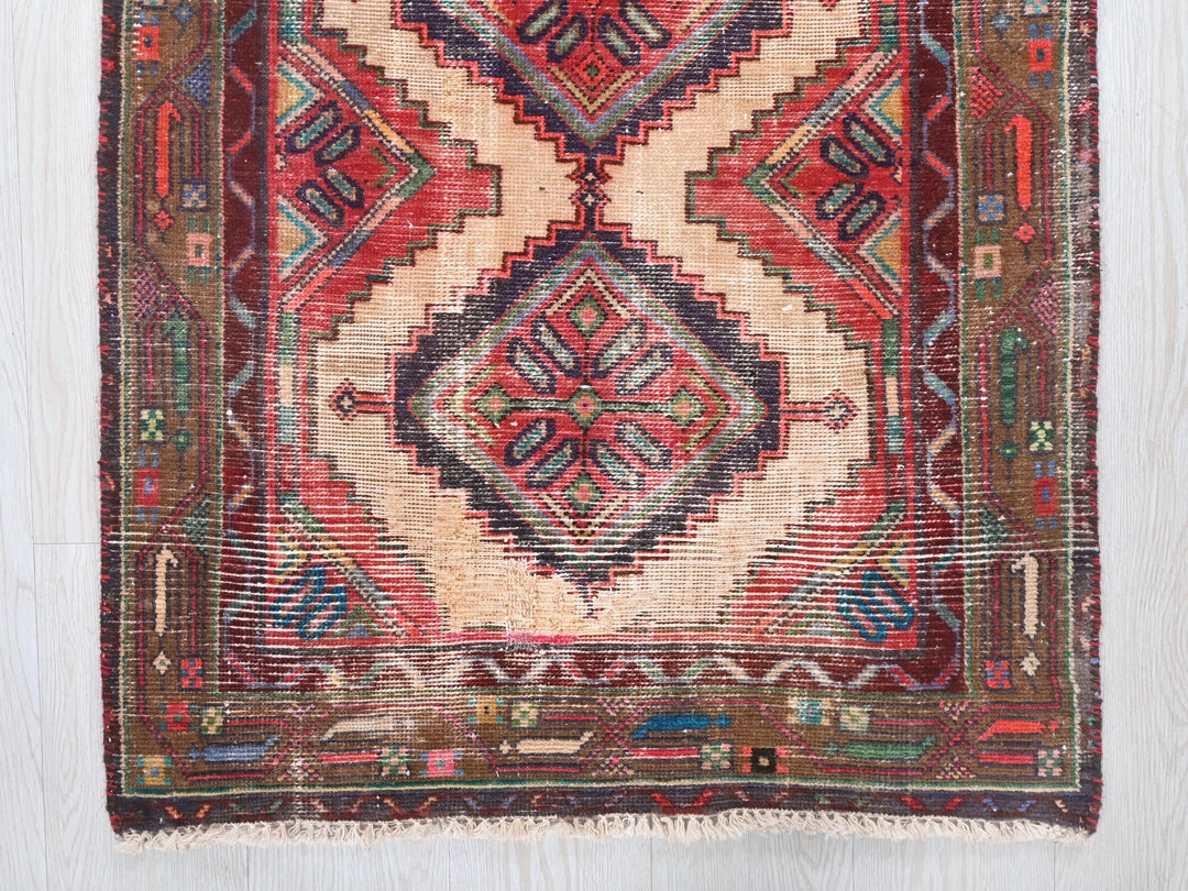 a red and blue rug on a wooden floor