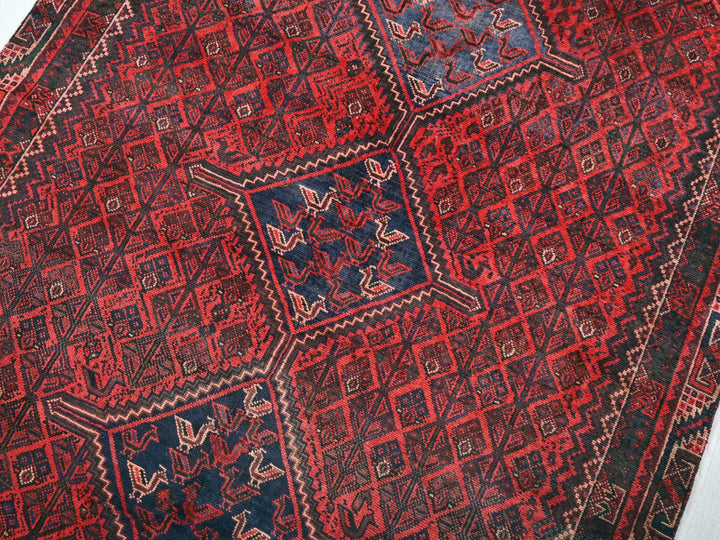 a red and blue oriental rug on a white surface