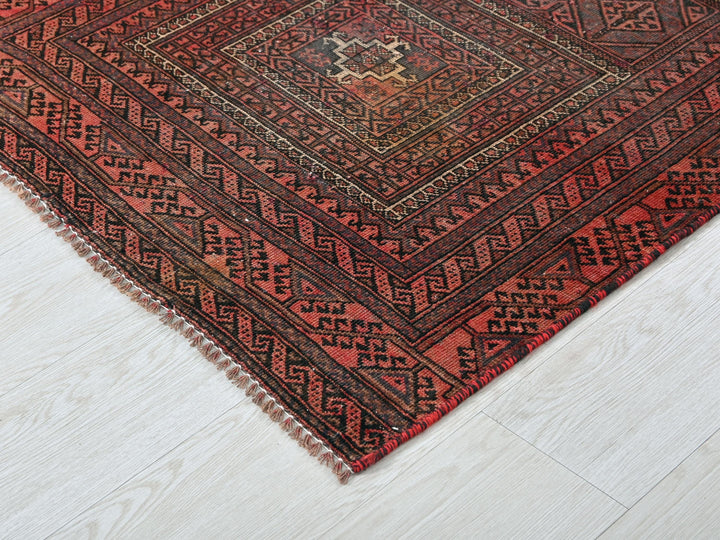 a red and black rug on a white floor