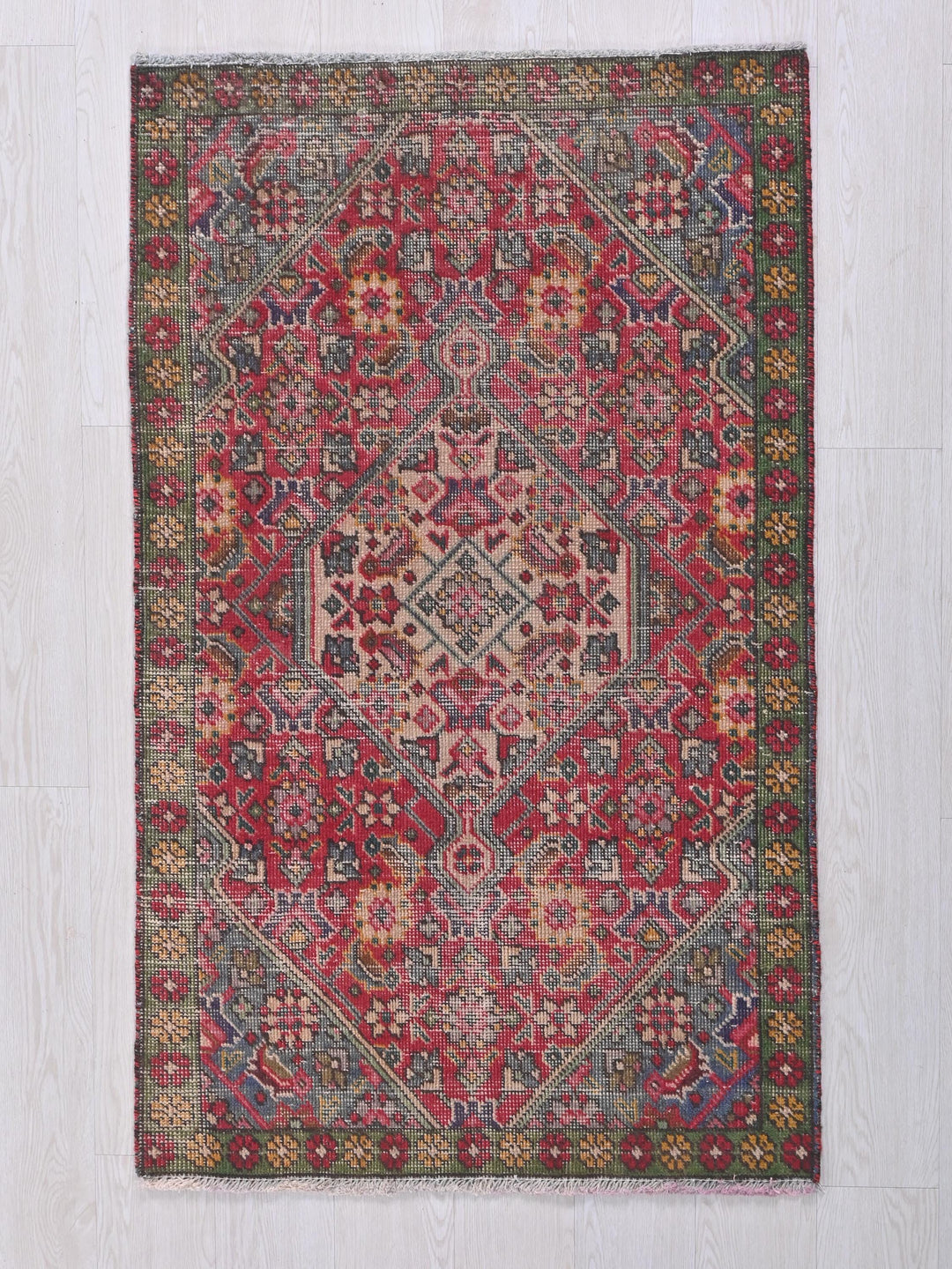 a red and blue rug on a white floor