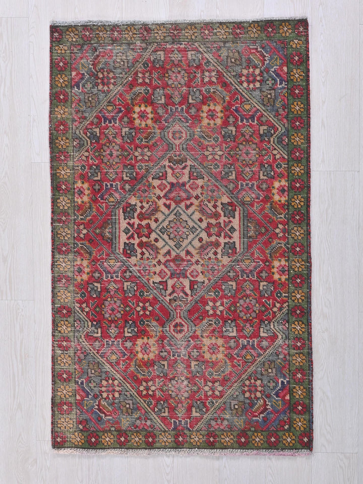 a red and blue rug on a white floor