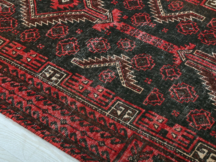 a close up of a red and black oriental rug