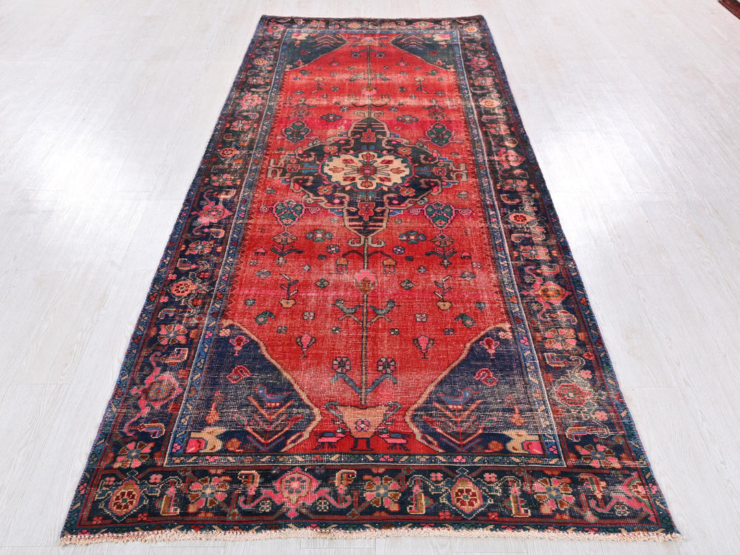 a red rug with a blue border on a white floor