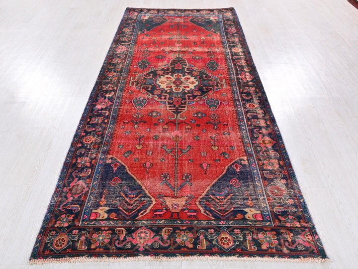 a red rug with a blue border on a white floor
