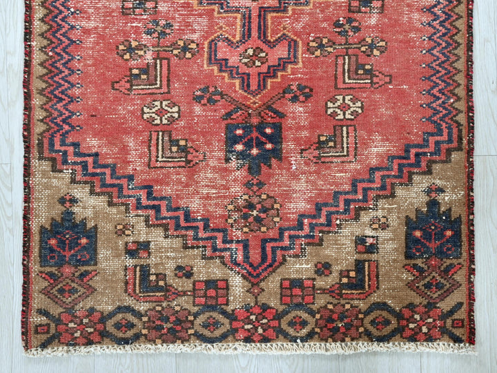 a red and blue rug on a wooden floor