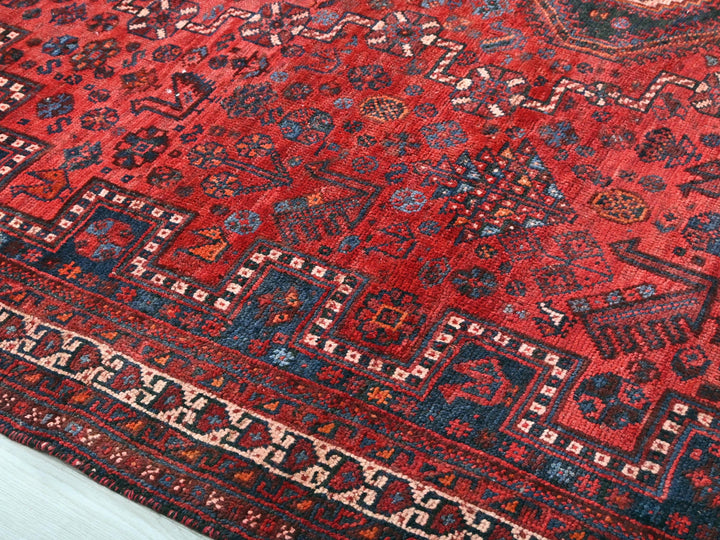 a red rug with a blue and red design on it