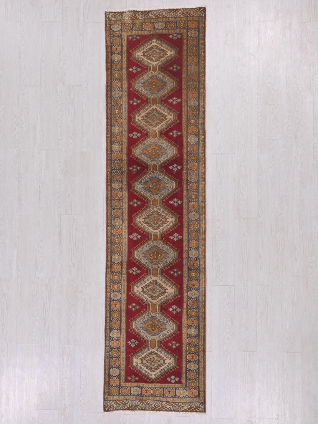 a long red rug hanging on a wall