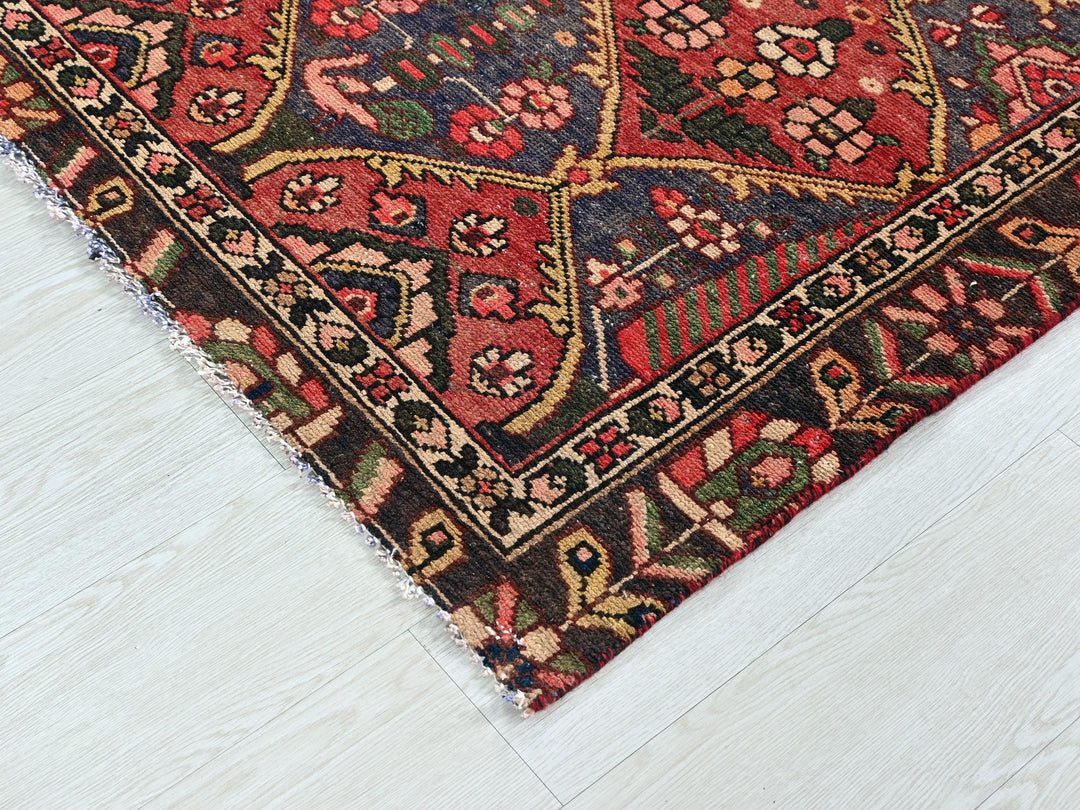 a red rug with a pattern on the middle of it