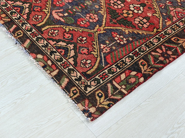 a red rug with a pattern on the middle of it