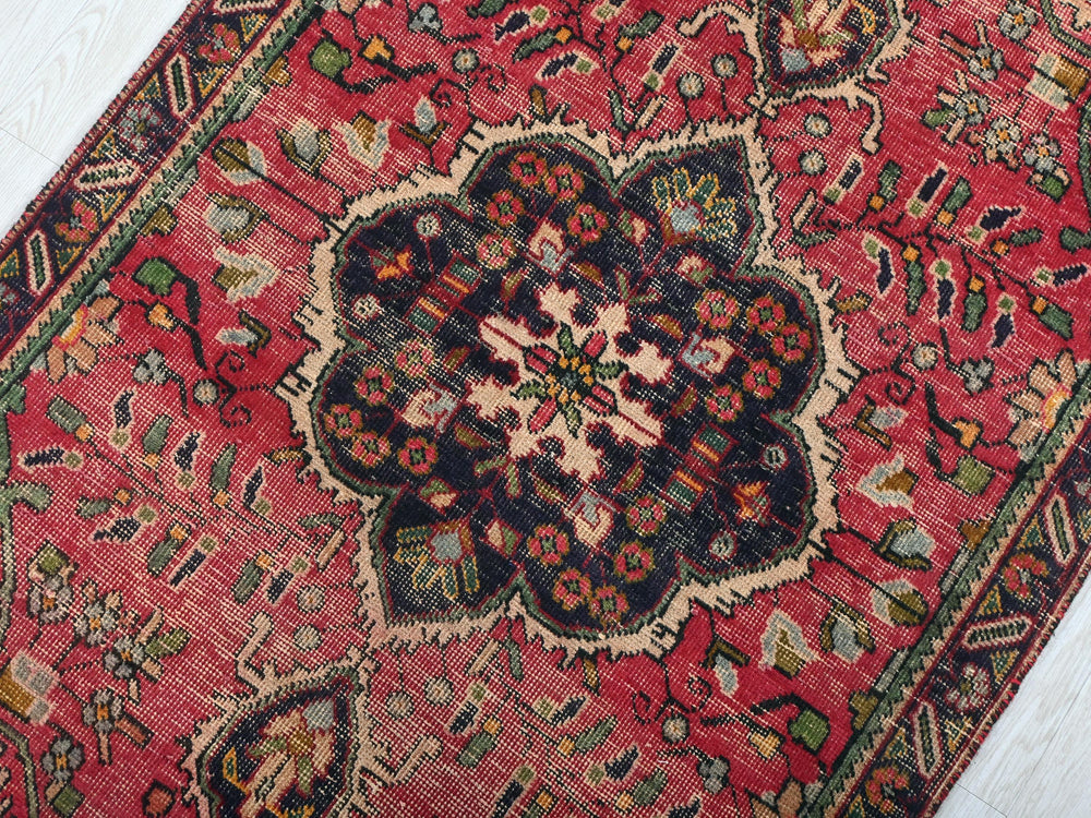 a red rug with a floral design on it
