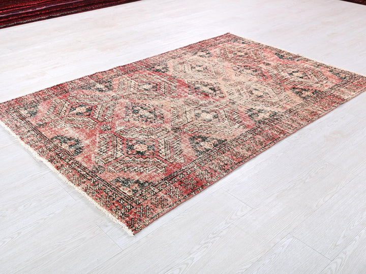 a red and black rug on a white floor