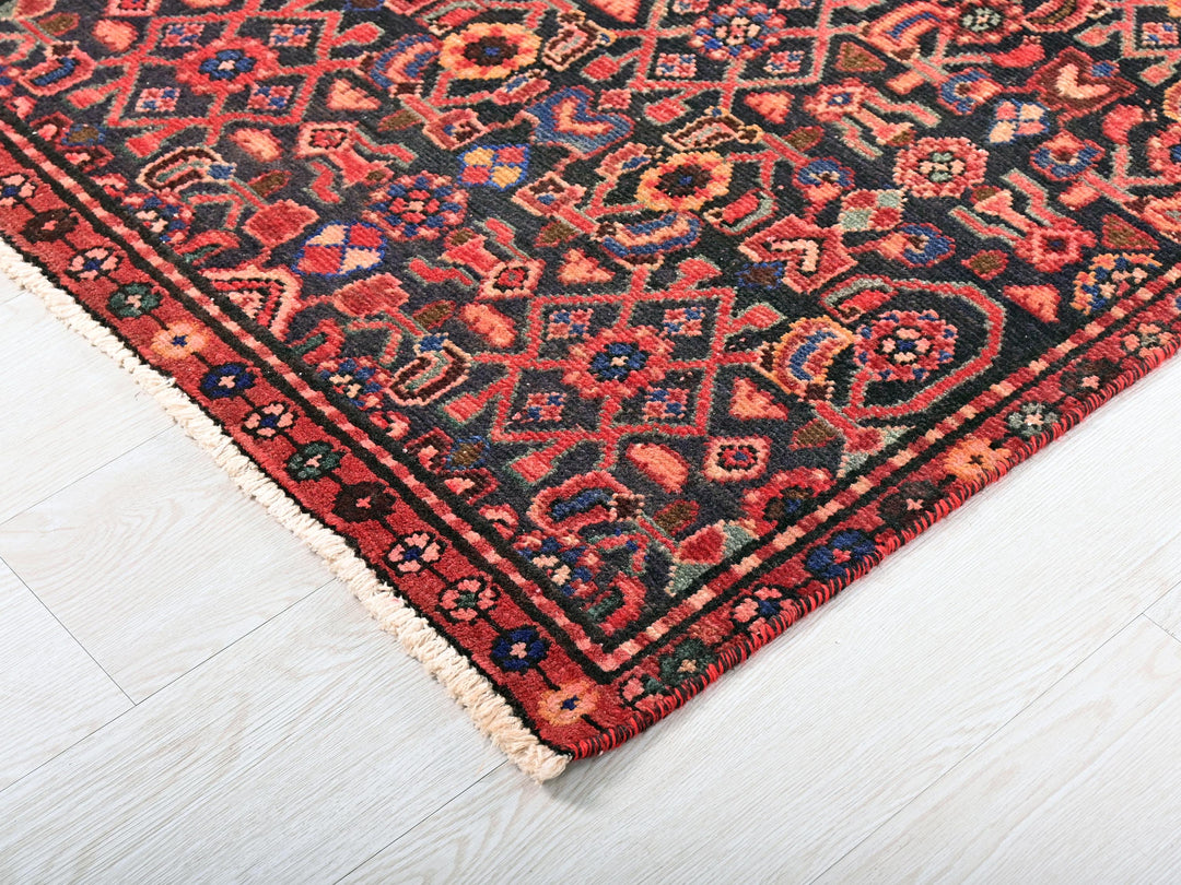 a red and black oriental rug on a white floor