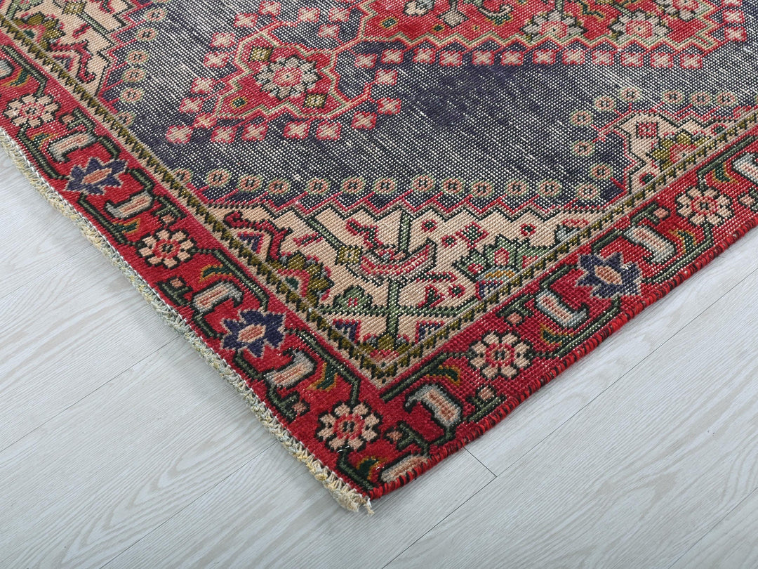 a red and blue rug on a white floor