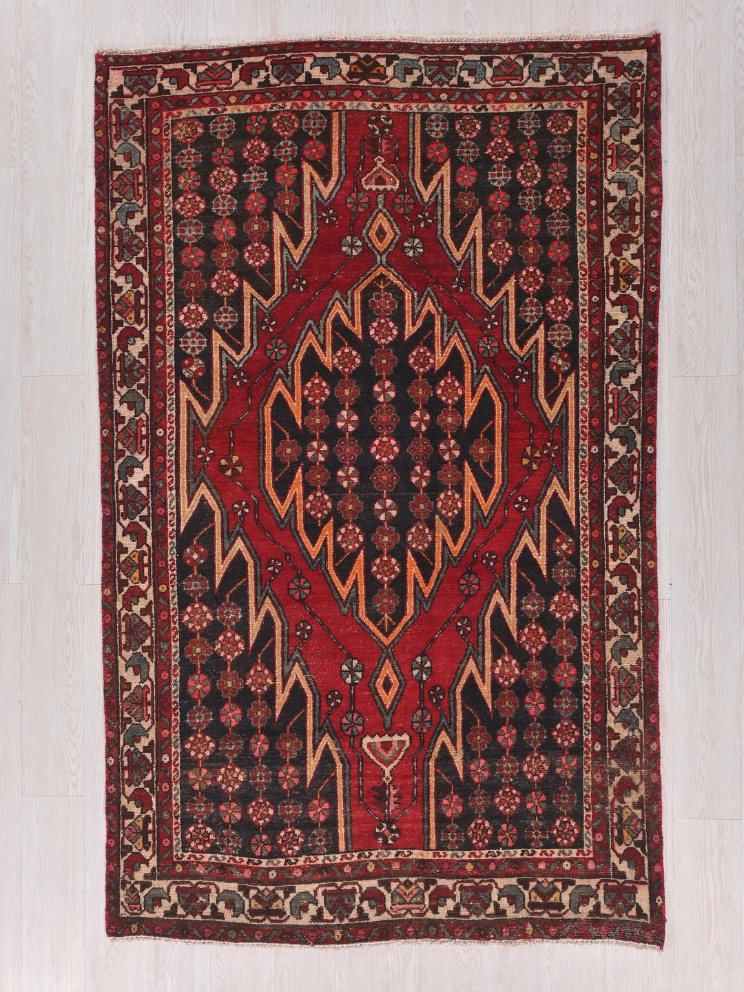 a red and black rug on a white floor