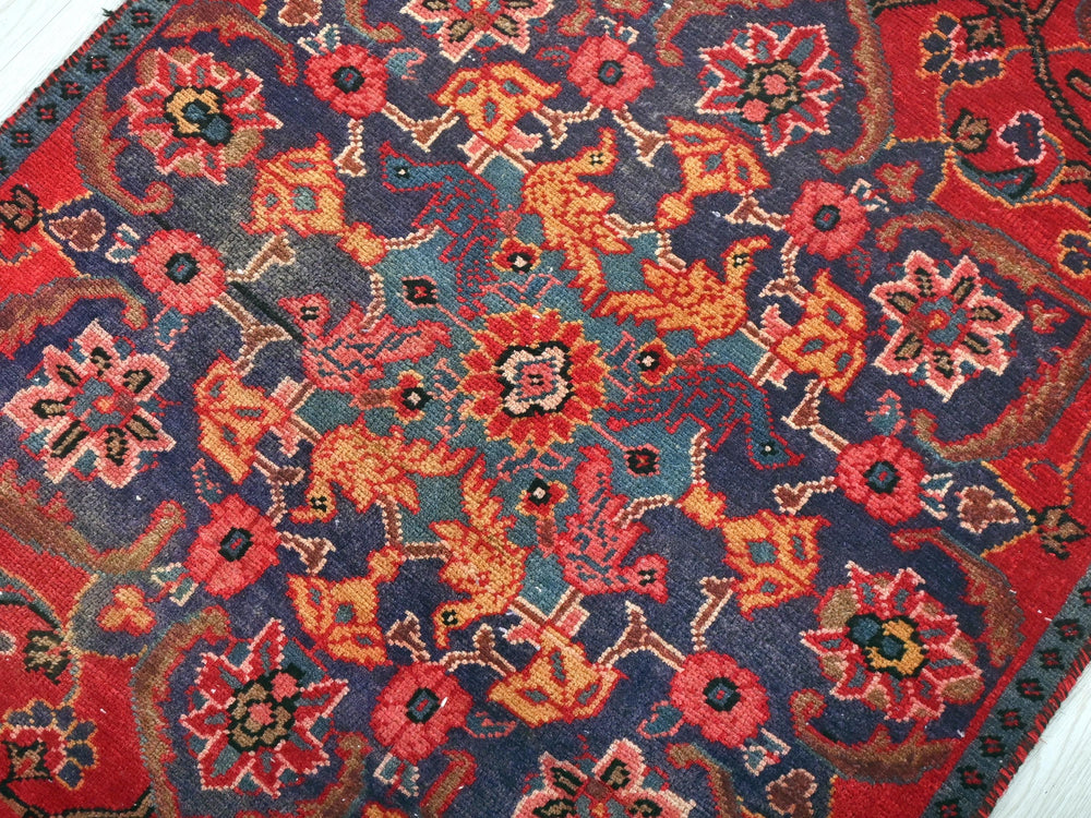 a red and blue oriental rug on a white floor