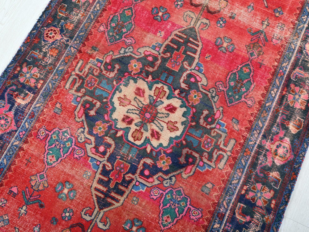 a red rug with a floral design on it