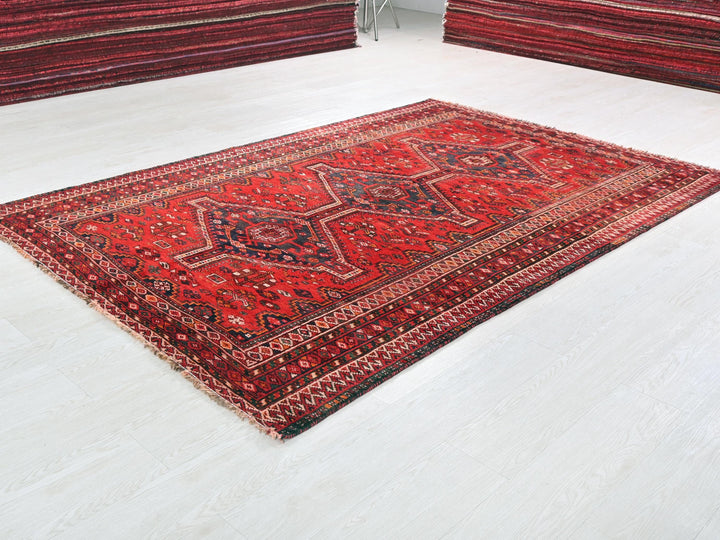 a red oriental rug on a white floor