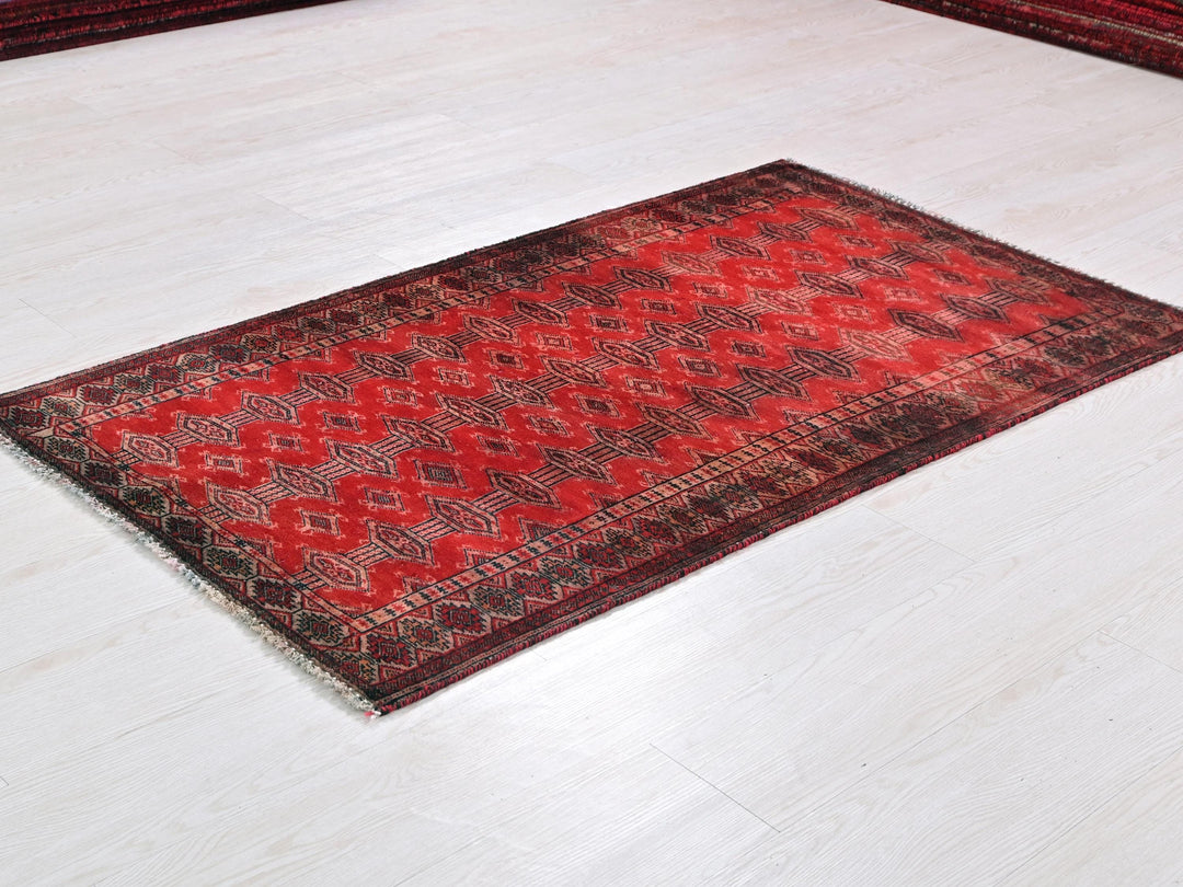 a red and black rug on a white floor