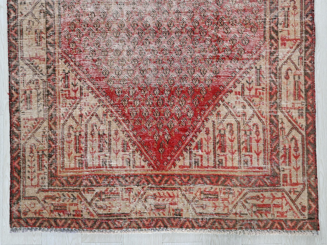 a red and beige rug on a white floor