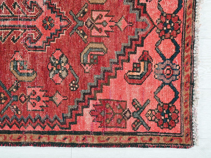 a red rug with a pattern on it