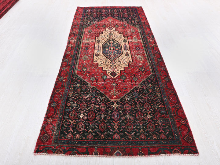 a red and black rug on a white floor