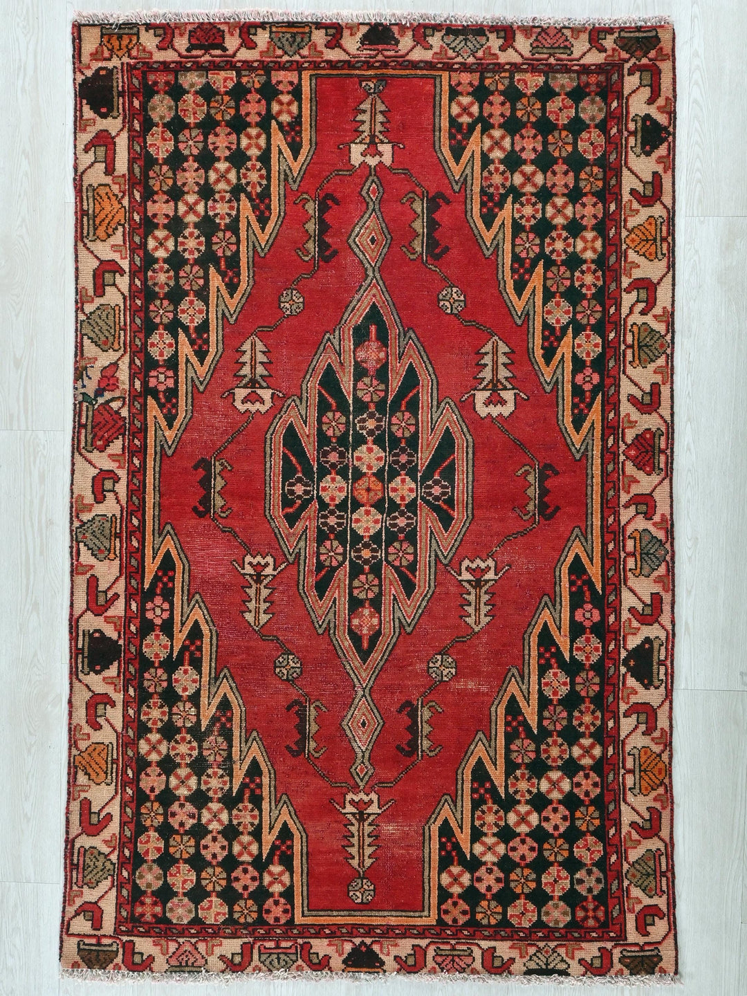 a red and black oriental rug on a white wall