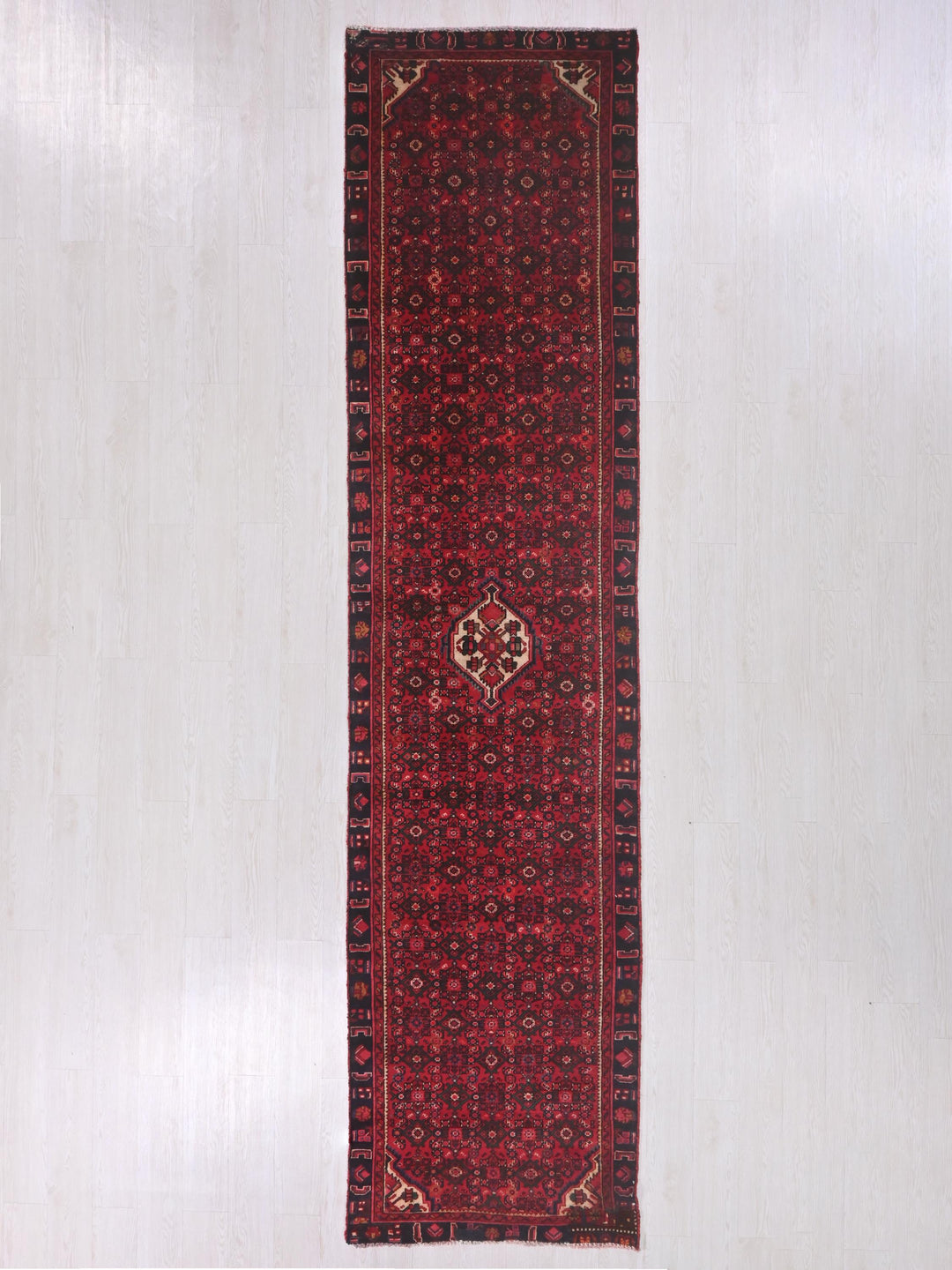 a long red rug hanging on a wall