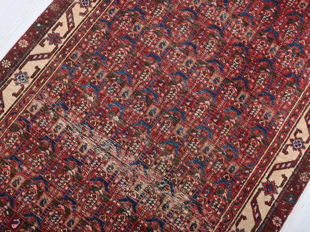 a red rug with a blue border on a white floor