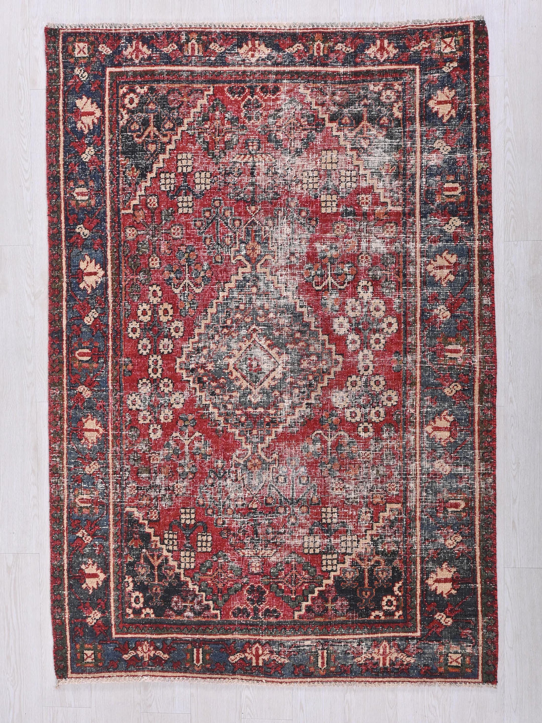 a red and blue rug with a diamond pattern