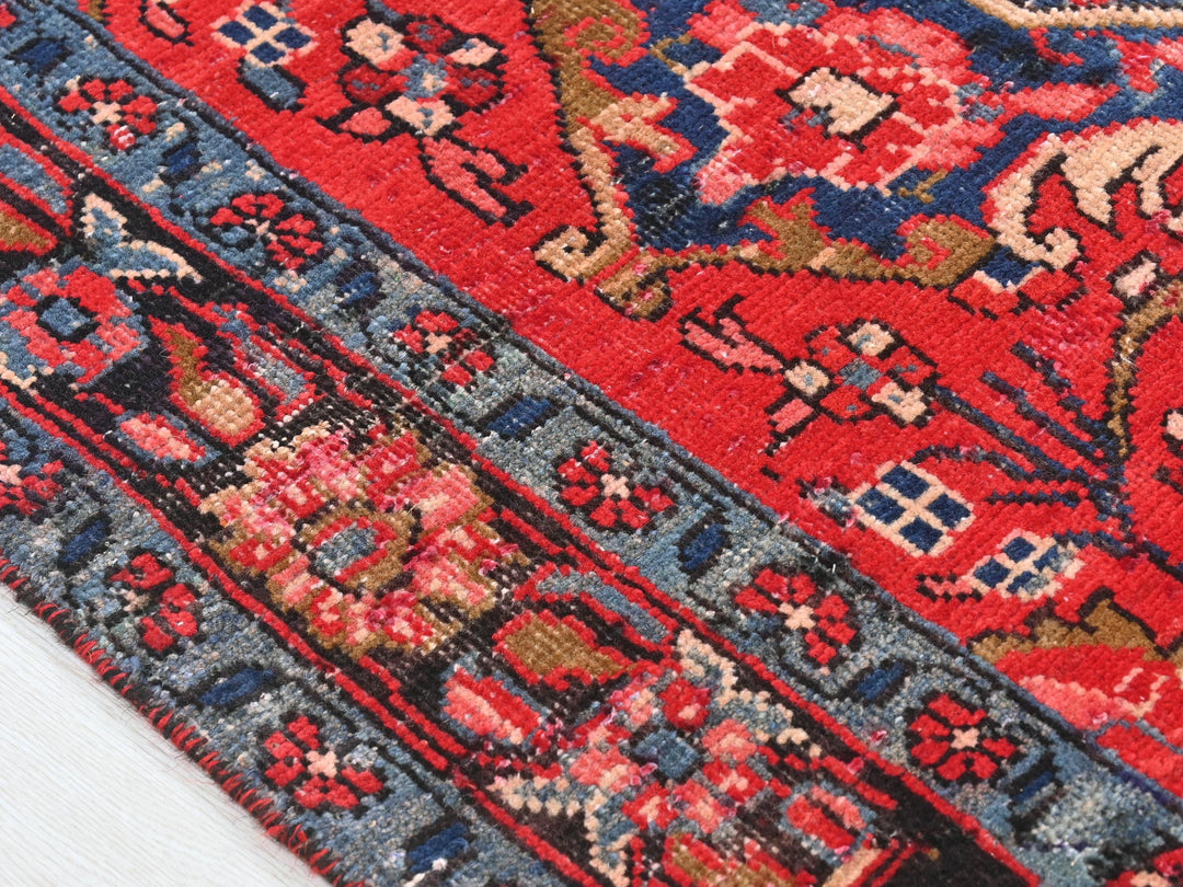 a close up of a red rug with blue and red designs