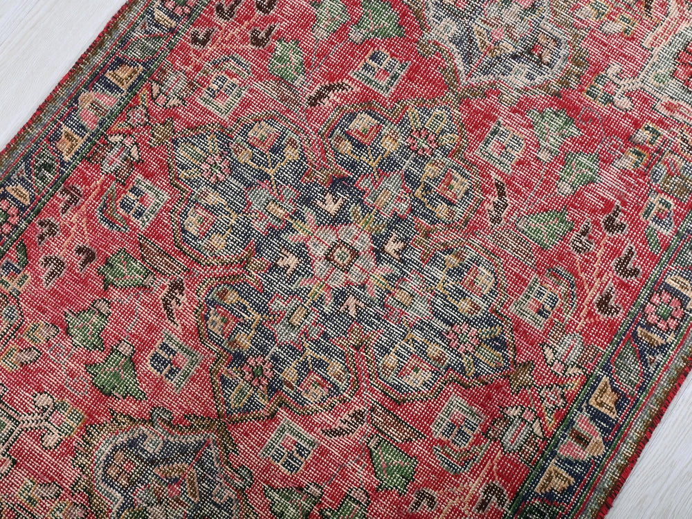 a red rug with a blue and green design on it