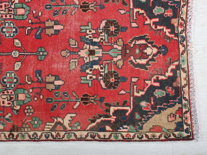 a red rug with a floral design on it
