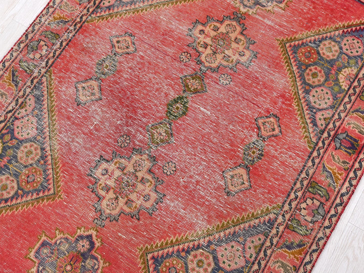 a red oriental rug with a floral design