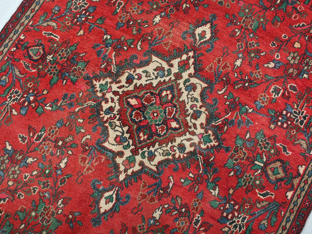 a red rug with a floral design on it